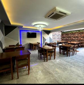 a dining room with wooden tables and chairs at mojo otel in Konak