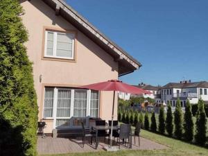 a house with a patio with a table and an umbrella at Domek Rowy in Rowy