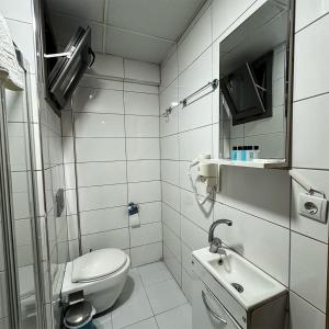 a white bathroom with a toilet and a sink at mojo otel in Konak