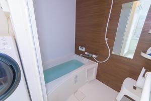 uma casa de banho com uma máquina de lavar roupa e um lavatório em fuu em Fukuoka