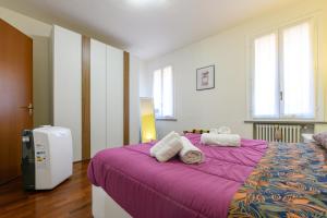 una camera da letto con un grande letto con lenzuola viola di Alex Dream a Reggio Emilia