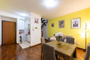 un soggiorno con tavolo e parete gialla di Alex Dream a Reggio Emilia
