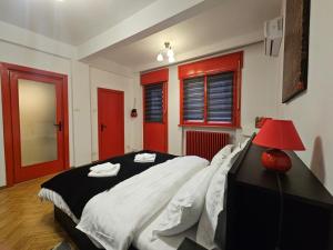 una camera con un grande letto e una lampada rossa di Red Velvet Residence a Bucarest