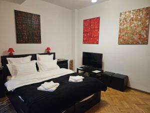 una camera con un grande letto e una televisione di Red Velvet Residence a Bucarest