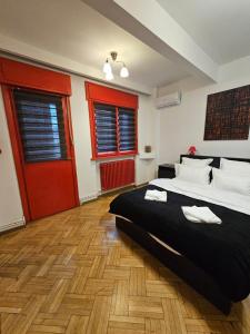 una camera con un grande letto e porte rosse di Red Velvet Residence a Bucarest