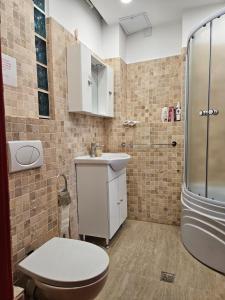 e bagno con servizi igienici, lavandino e doccia. di Red Velvet Residence a Bucarest