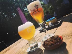 een tafel met twee glazen bier en een kom eten bij Camping de Boskant in Guelle
