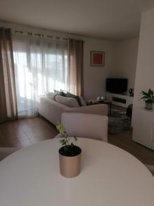 sala de estar con mesa blanca y sofá en Chambre double avec salle de bain commune, a 2 min de la Croisette, en Cannes