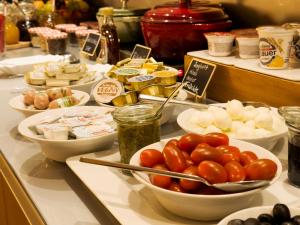 a buffet with bowls of tomatoes and other foods at Grimm's Berlin Mitte in Berlin