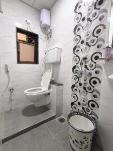 een badkamer met een toilet en een muur met krullen bij Sapna Lodging & Boarding in Mumbai