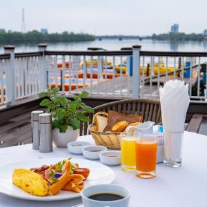 una mesa con un plato de comida y zumo de naranja en Castle Bayview Resort & Spa, en Kampot