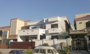 a white building with cars parked in front of it at Morbex Guest House Islamabad in Islamabad