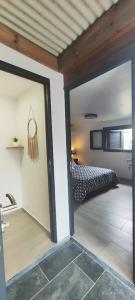 a room with a bed and a sliding glass door at Tiny house Les Cactus - Bungalow St Gilles les hauts in Saint-Paul