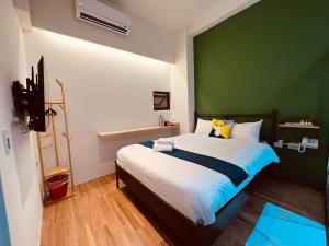 a bedroom with a large bed with a green wall at 日月潭沅居民宿 YUAN JU BOUTIQUE Hotel in Yuchi