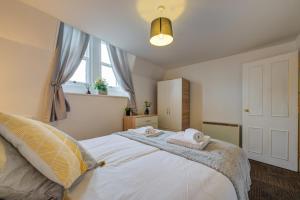 een slaapkamer met een bed met twee handdoeken erop bij 1Bed - Contractor-Friendly Apartment - High Street Views in Stamford
