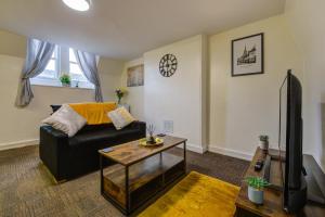 een woonkamer met een bank en een tafel bij 1Bed - Contractor-Friendly Apartment - High Street Views in Stamford