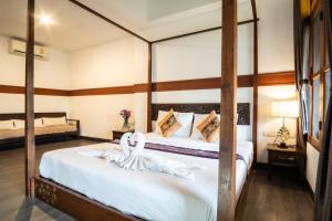 a bedroom with two beds with swans on the bed at Hugga Pai in Pai