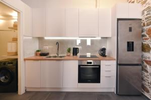 a white kitchen with a sink and a refrigerator at Ledio's house in Ermoupoli