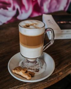 een kopje koffie en koekjes op een tafel bij Godiva Spa & Guesthouse in Groblersdal