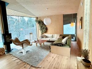 un salon avec un canapé et une table dans l'établissement Villa Jäkälä - An architectural wooden villa by the lake, à Rokua