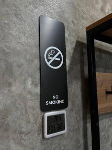 a no smoking sign next to a clock on a wall at DEMAL HOTEL in Petropavlovsk