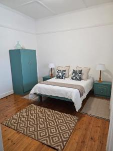 Harry's Place Guesthouse في Kamieskroon: غرفة نوم عليها سرير ومخدات