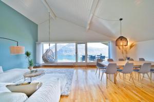 un soggiorno con divano bianco e tavolo di Dreamview Retreat - Breathtaking Lake Views a Krattigen