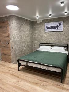 - une chambre avec un grand lit et une couverture verte dans l'établissement DEMAL HOTEL, à Petropavlovsk-Kamtchatski