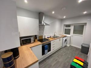 uma cozinha com armários brancos e um forno com placa de fogão em Maritime House One - Hull em Hull