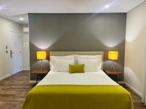 a bedroom with a large bed with two lamps at Casa Jerónimo B&B in Peso da Régua