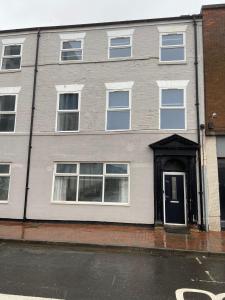 a gray building with a black door on a street at Maritime House One - Hull in Hull