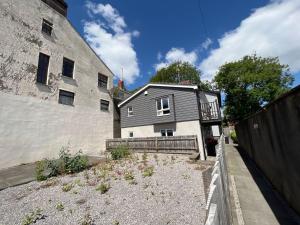 a gray and white house next to a building at Pass the Keys Perfectly located stylish 2 bed home with Parking in Newport