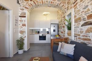 a kitchen and living room with a brick wall at Ledio's house in Ermoupoli +17 photos