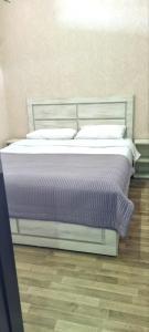 a bed in a bedroom with purple sheets and pillows at Kate's cozy apartment in Kutaisi +17 photos
