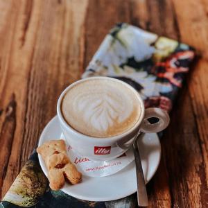 a cup of coffee and cookies on a plate at Godiva Spa & Guesthouse in Groblersdal