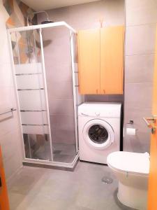 uma pequena casa de banho com uma máquina de lavar roupa em Appartement Clube Praia Da Rocha III em Portimão