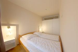 1 dormitorio con 1 cama blanca y armario blanco en Apartment 555, en Hohegeiss