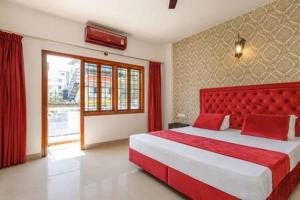 um quarto com uma cama grande e uma cabeceira vermelha em Elegant Apartment by JadeCaps Wifi Private balcony em Bangalore