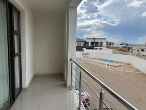 a balcony with a view of a swimming pool at Apartment close to Golf Course! in Windhoek