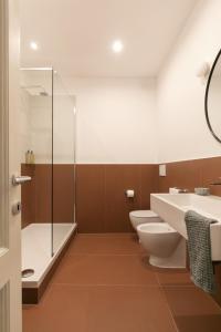 ein Badezimmer mit 2 WCs und einer Dusche in der Unterkunft Passepartout in Rom