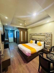 a bedroom with a large bed and a desk and a desk at HOTEL COSMOS in Lucknow