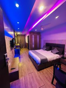 a bedroom with a bed with purple lights on it at HOTEL COSMOS in Lucknow