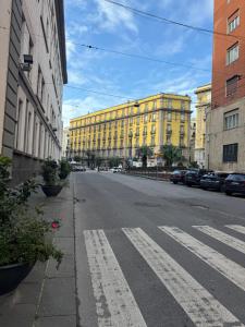 una calle urbana vacía con un edificio amarillo en Maison Angioino en Nápoles