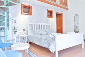 a white bedroom with a bed and a table at Chiaia Sea View Gem in Naples
