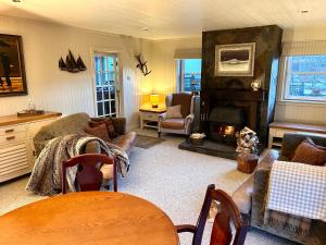 a living room with a couch and a fireplace at Strathlachlan Lodge, Luxury Country House with Hot tub & Sauna in Strachur
