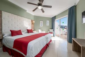 a bedroom with a large bed with a ceiling fan at Los Arcos in Nerja