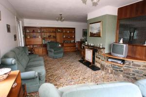 a living room with couches and a stone fireplace at Dwy Olwyn in Dolgellau