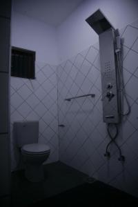 a bathroom with a toilet in a dark room at The Waterbubble Guest in Digana