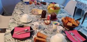 a table with a table cloth with food and bread at Chambres d'Hôtes Le Menestrel in Les Eyzies-de-Tayac