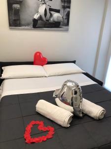 a bed with a red heart and towels on it at Maremma10 in Turin